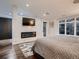 Primary bedroom featuring a fireplace, TV, large window, and sliding door to a balcony at 338 Saint Paul St, Denver, CO 80206