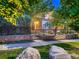 Charming two-story brick home with lush landscaping, rock detail, and a cozy front patio at 338 Saint Paul St, Denver, CO 80206