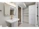 Well-lit bathroom featuring a pedestal sink, gold fixtures, built-in storage, and tile flooring at 3603 Soaring Eagle Ct, Castle Rock, CO 80109