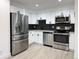 Modern kitchen featuring stainless steel appliances and dark hexagon backsplash at 4899 S Dudley # 1I, Littleton, CO 80123