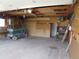 An empty garage features a lift, open ceiling, shelving, heater, and plenty of storage space at 5660 Olive St, Commerce City, CO 80022