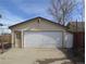 A detached two-car garage with an additional side door and a white garage door at 5660 Olive St, Commerce City, CO 80022