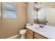 Half bathroom with wood vanity, laminate flooring, window, toilet, and large mirror at 12616 Country Meadows Dr, Parker, CO 80134