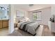 Bedroom featuring neutral decor, window with blinds, and a glimpse of the ensuite bathroom at 12616 Country Meadows Dr, Parker, CO 80134