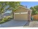 View of the home's garage, showing a tan facade with brick accents and a well-kept driveway at 12616 Country Meadows Dr, Parker, CO 80134