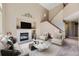 Staged living room with high ceilings, fireplace, mantel, and staircase at 12616 Country Meadows Dr, Parker, CO 80134