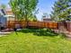Spacious backyard featuring a lush lawn, patio with dining area, and a relaxing hammock at 4453 S Pagosa Way, Aurora, CO 80015