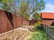 Spacious backyard with a garden bed, wood fence, and a backdrop of mature trees for added privacy at 4453 S Pagosa Way, Aurora, CO 80015