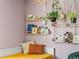 Charming bedroom showcasing decorative shelves filled with books and lush hanging plants against soft lavender walls at 4453 S Pagosa Way, Aurora, CO 80015