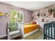 Cozy bedroom with a comfortable bed, accent chair, and shelves adorned with books and charming decor at 4453 S Pagosa Way, Aurora, CO 80015