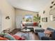 Cozy living room featuring a plush sectional couch, plants, and a view of the backyard at 4453 S Pagosa Way, Aurora, CO 80015