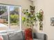 Bright living room with plants, a view of the neighborhood, and a comfortable gray couch at 4453 S Pagosa Way, Aurora, CO 80015
