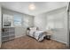 Bedroom features carpet, natural light from two windows, a closet, and a mirror at 11712 Lewiston St, Commerce City, CO 80022