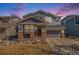 Charming two-story home featuring a covered porch with brick accents and a well-maintained front lawn at 11712 Lewiston St, Commerce City, CO 80022