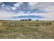Distant aerial view of the house from across a meadow and behind a split rail fence at 3487 Willownook Ranch Trl, Elizabeth, CO 80107