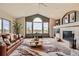 Bright living room with vaulted ceilings, large windows showcasing the view, and a cozy fireplace at 3487 Willownook Ranch Trl, Elizabeth, CO 80107