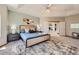 Bright main bedroom with a tray ceiling, and view of the living room and stylish nightstands at 3487 Willownook Ranch Trl, Elizabeth, CO 80107