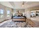 Spacious main bedroom with a tray ceiling, large windows, and a view into the cozy living room at 3487 Willownook Ranch Trl, Elizabeth, CO 80107