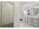 Bright bathroom featuring a glass enclosed shower, console sink, and a window providing natural light at 4508 Lowell Blvd, Denver, CO 80211