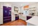 Modern kitchen with a purple refrigerator, stainless steel appliances, and hardwood floors at 4508 Lowell Blvd, Denver, CO 80211