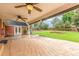 Covered patio with stamped concrete and fans, overlooking a beautiful lawn with garden beds at 3 Glenview Dr, Littleton, CO 80123