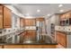Spacious kitchen featuring granite countertops, stainless steel appliances, and brick accent wall at 3 Glenview Dr, Littleton, CO 80123