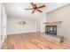 Spacious living room featuring hardwood floors, ceiling fan and a beautiful brick fireplace at 3 Glenview Dr, Littleton, CO 80123
