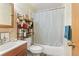 Traditional bathroom with a bathtub and shower, vanity, and a toilet with shelving at 19335 E Batavia Pl, Aurora, CO 80011