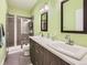 Modern bathroom with double vanity, shower, and green walls at 1537 W 43Rd Ave, Denver, CO 80211