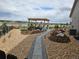 A beautiful backyard has stone walkways, gravel, mulch, and a charming pergola with stone pillars at 23696 E Del Norte Pl, Aurora, CO 80016