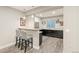 Basement bar featuring barstool seating, stone countertops, wood cabinetry, and modern pendant lighting at 23696 E Del Norte Pl, Aurora, CO 80016