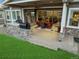 Wonderful covered patio featuring a stone fireplace, outdoor kitchen, ceiling fans, and an attractive dining set at 23696 E Del Norte Pl, Aurora, CO 80016