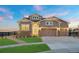 Charming home with stone accents, a three-car garage, and a beautifully landscaped front yard at 23696 E Del Norte Pl, Aurora, CO 80016