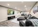 Spacious basement living room featuring a large sofa, entertainment center and an adjacent dining area at 23696 E Del Norte Pl, Aurora, CO 80016