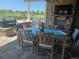 Charming outdoor kitchen and dining area with a built-in grill, fireplace, and comfortable seating at 23696 E Del Norte Pl, Aurora, CO 80016
