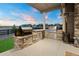 Outdoor kitchen with built-in grill, stone counter, stainless steel storage, and a patio heater at 23696 E Del Norte Pl, Aurora, CO 80016
