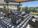 Cozy outdoor seating area featuring a built-in stone fire pit, comfortable seating, and a covered pergola at 23696 E Del Norte Pl, Aurora, CO 80016