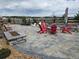 Cozy backyard patio area with stone pavers, a fire pit, several chairs, and an outdoor fireplace for entertaining at 23696 E Del Norte Pl, Aurora, CO 80016