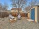 Backyard featuring a fire pit area with stone pavers, chairs, and a shed with a blue door at 11395 E 116Th Dr, Commerce City, CO 80640