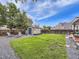 Grassy backyard with storage shed, stone firepit, Adirondack chairs, and wooden fence, great for relaxation at 11395 E 116Th Dr, Commerce City, CO 80640