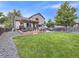 Expansive backyard with a deck, pergola, dining area, lush lawn, and cozy seating, perfect for outdoor living at 11395 E 116Th Dr, Commerce City, CO 80640