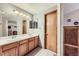 Bright bathroom featuring a double vanity with light wood cabinets and a large mirror at 11395 E 116Th Dr, Commerce City, CO 80640