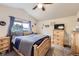 Comfortable bedroom with natural wood furniture, a large window, and a vaulted ceiling at 11395 E 116Th Dr, Commerce City, CO 80640