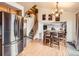 Open dining area features hardwood floors, staircase, and stainless steel fridge at 11395 E 116Th Dr, Commerce City, CO 80640