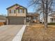 Charming two-story home featuring stone accents, a two-car garage, and manicured landscaping at 11395 E 116Th Dr, Commerce City, CO 80640