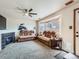 Cozy living room features neutral carpet, fireplace, ceiling fan and bay window at 11395 E 116Th Dr, Commerce City, CO 80640