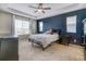 Spacious bedroom with a blue accent wall, a tray ceiling, and large windows at 3810 Cadence Dr, Castle Rock, CO 80109