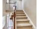 Carpeted staircase featuring a wood banister and bright, natural light at 3810 Cadence Dr, Castle Rock, CO 80109