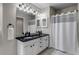 Well-lit bathroom featuring a double sink vanity with black countertops and a shower-tub combo at 35427 Welch Trl, Elizabeth, CO 80107