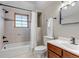 Neutral bathroom featuring tiled walls, a wood-framed window, and matching wooden vanity at 35427 Welch Trl, Elizabeth, CO 80107